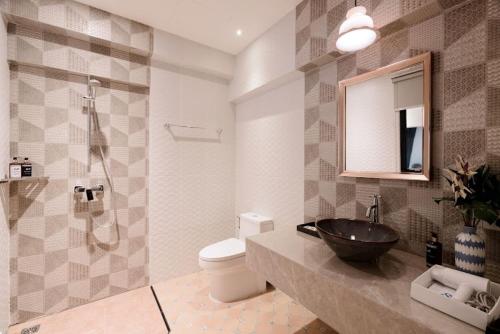 a bathroom with a sink and a toilet and a mirror at Sabai Hotel Aonang in Ao Nang Beach