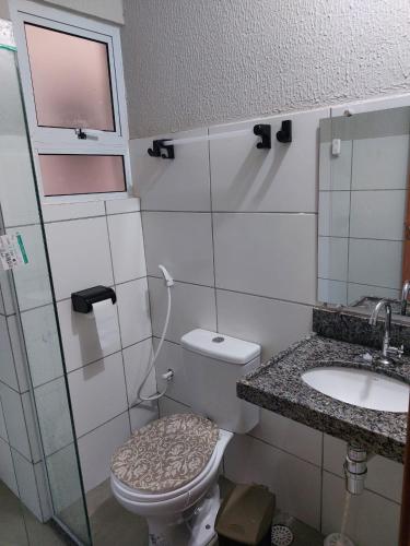 a bathroom with a toilet and a sink at Aconchego Atalaia in Luis Correia