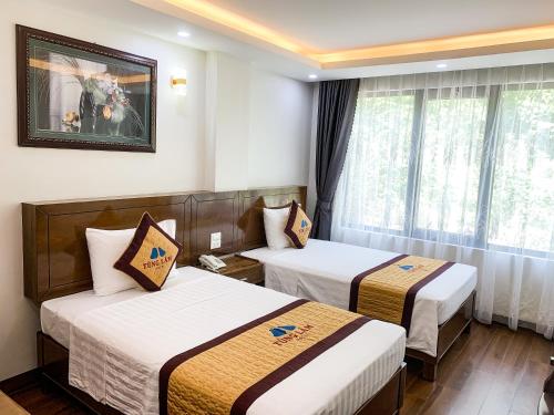 um quarto de hotel com duas camas e uma janela em TÙNG LÂM HOTEL em Ha Long