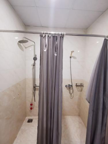 a shower with a gray shower curtain in a bathroom at Sen Vàng Hotel in Xã Thang Tam