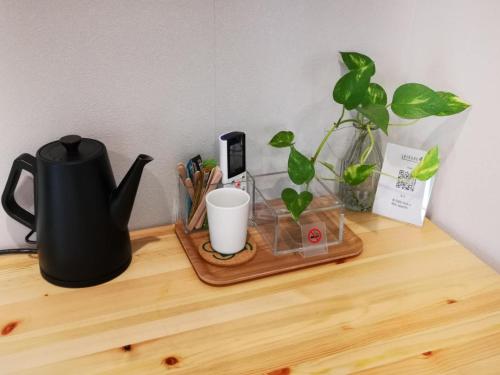 a desk with a tea kettle and a plant on it at Leisure hotel 中野 in Tokyo