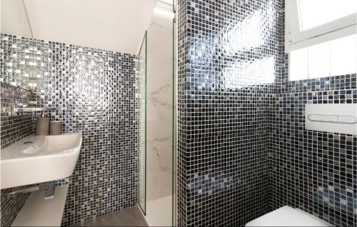 a bathroom with a sink and a shower with black tiles at Nice Home In Gran Canaria With Outdoor Swimming Pool in Pasito Blanco