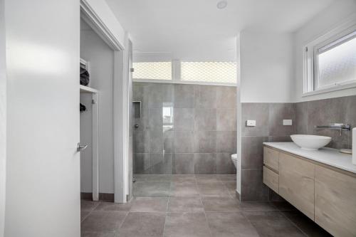 a bathroom with a shower and a toilet and a sink at At Agnes Ave: coastal views in Blairgowrie