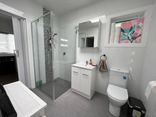 y baño blanco con aseo y ducha. en Modern 1 bedroom studio free parking close to CBD, en Burnie