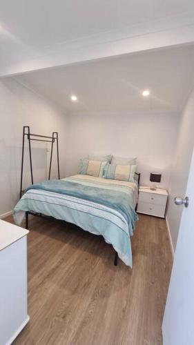 a bedroom with a bed in a white room at Modern 1 bedroom studio free parking close to CBD in Burnie