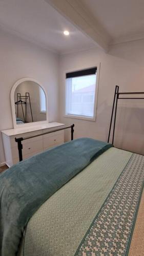 1 dormitorio con cama, lavabo y espejo en Modern 1 bedroom studio free parking close to CBD, en Burnie