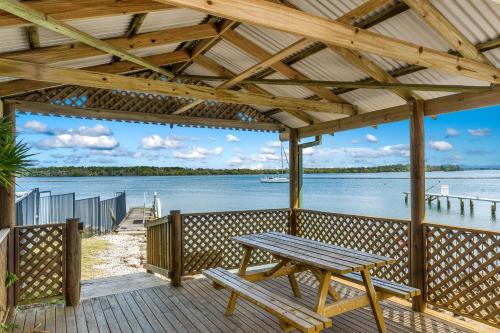 a wooden deck with a picnic table and a view of the water at Iluka Villa 10 in Iluka