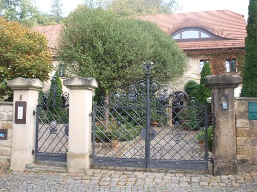 a black gate in front of a house at Pension zur Königlichen Ausspanne Dresden in Dresden