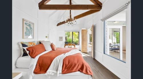 1 dormitorio con 1 cama con manta naranja en Daylesford Lake Garden Villas, en Daylesford