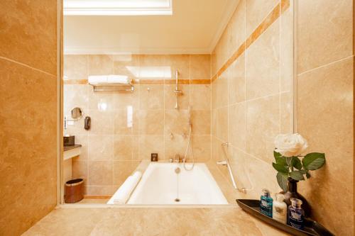 a bathroom with a bath tub in a room at Lotte Hotel Saigon in Ho Chi Minh City