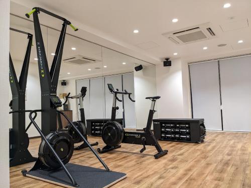 a gym with treadmills and exercise bikes in a room at Park Hotel Kyoto in Kyoto