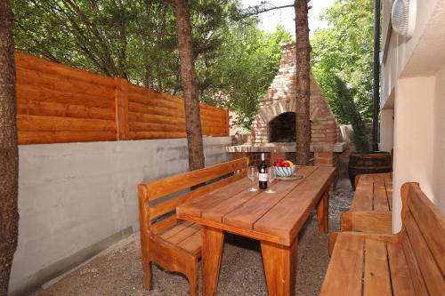a wooden table and bench with a pizza oven at Apartments by the sea Ribarica, Karlobag - 15907 in Ribarica