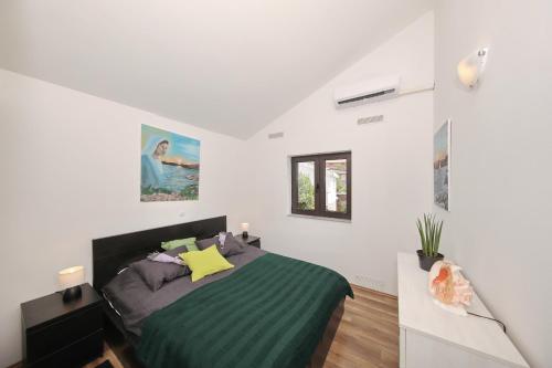 a bedroom with a bed in a white room at Apartments by the sea Ribarica, Karlobag - 15907 in Ribarica