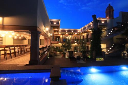a villa with a swimming pool at night at Concepción Hotel Boutique - Adults Only in San Miguel de Allende