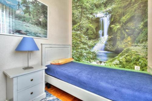 sypialnia z malowidłem wodospadowym na ścianie w obiekcie Apartments with a parking space Umag - 15941 w mieście Umag