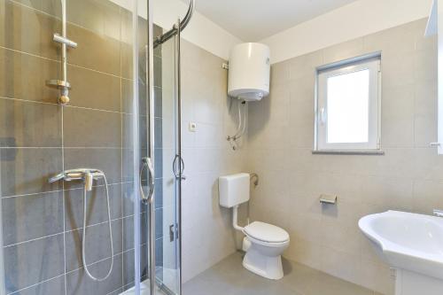 a bathroom with a shower and a toilet and a sink at Apartments with parking space Vrsi, Zadar - 15944 in Vrsi