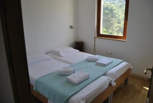 sypialnia z 2 łóżkami i ręcznikami w obiekcie Holiday house with a swimming pool Stomorska, Solta - 15950 w mieście Grohote