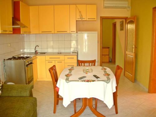 Apartments by the sea Vis - 15926 في فيس: مطبخ مع طاولة ومطبخ مع دواليب صفراء