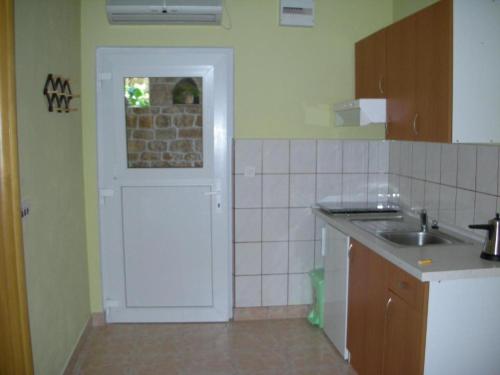 eine Küche mit einer weißen Tür und einem Waschbecken in der Unterkunft Apartments by the sea Vis - 15926 in Vis