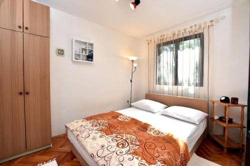 um quarto com uma cama grande e uma janela em Apartments by the sea Rogac, Solta - 16223 em Grohote