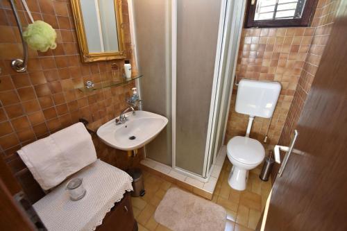 uma casa de banho com um chuveiro, um lavatório e um WC. em Apartments by the sea Rogac, Solta - 16223 em Grohote