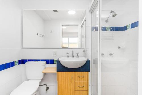 a white bathroom with a sink and a toilet at Riverview Apartment 2 Block 2 in Iluka