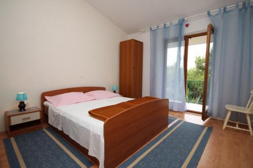 sypialnia z łóżkiem i dużym oknem w obiekcie Apartments by the sea Brela, Makarska - 2713 w Breli