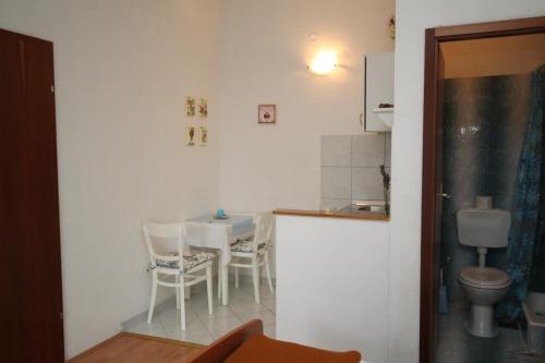 een kleine keuken met een tafel en stoelen in een kamer bij Apartments by the sea Brela, Makarska - 2713 in Brela