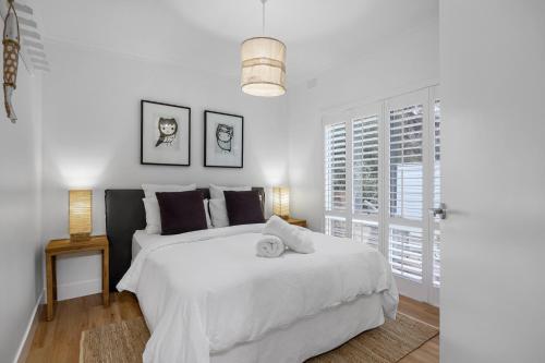 a white bedroom with a white bed and a window at Capella Villa No. 4 - stunning luxury decor inside and out in Blairgowrie