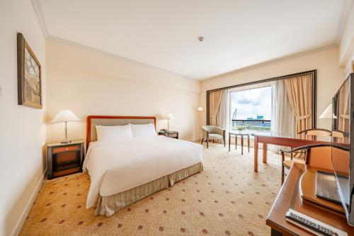 a hotel room with a large bed and a desk at Lotte Hotel Saigon in Ho Chi Minh City