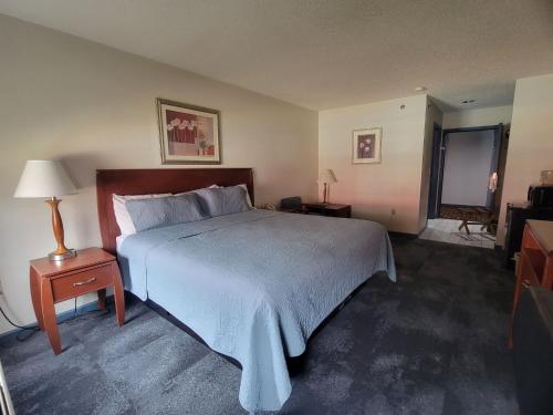 a bedroom with a large bed with a blue blanket at CountrySide Inn in Nappanee
