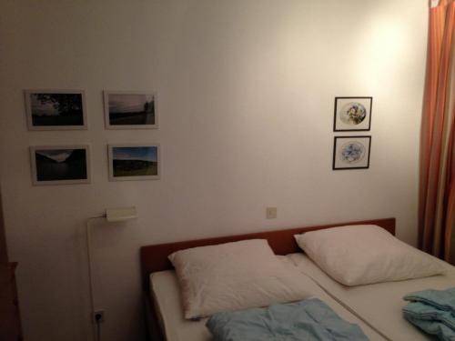 シェーンヴァルトにあるHaus Brunhilde App 3 - Sängerのベッドルーム1室(ベッド1台付)が備わります。壁には絵画が飾られています。