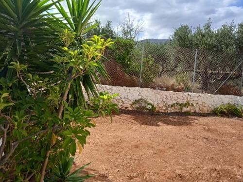 einen Garten mit einer Schutzwand und einem Zaun in der Unterkunft Malia Private Yard in Pírgos