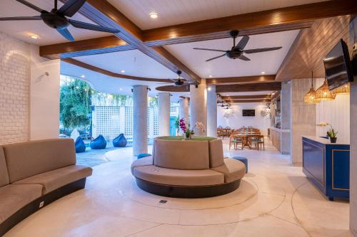 a living room with a ceiling fan and a couch at The Beach House Resort in Gili Trawangan