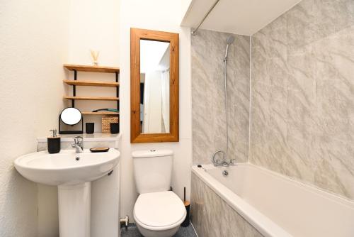 La salle de bains est pourvue d'un lavabo, de toilettes et d'une baignoire. dans l'établissement The John Muir - Beautiful 1 bed apartment in Helensburgh, à Helensburgh