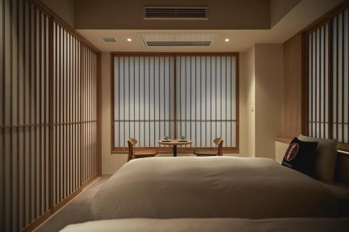 um quarto com uma cama grande e uma janela grande em THE HOTELS HAKATA Harushige SHINKAN em Fukuoka