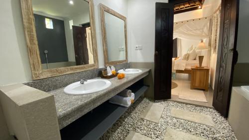 baño con 2 lavabos y espejo grande en The Palms Canggu, en Canggu
