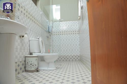 a white bathroom with a toilet and a sink at Hoima Buffalo Hotel & Business Hub LTD in Hoima