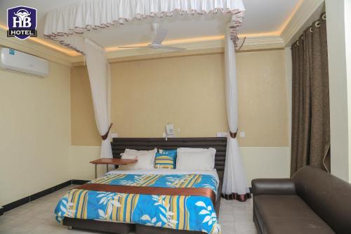 ein Schlafzimmer mit einem Bett und einem Sofa in der Unterkunft Hoima Buffalo Hotel & Business Hub LTD in Hoima