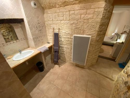 łazienka z umywalką i kamienną ścianą w obiekcie La Fontaine de Vinsobres w mieście Vinsobres