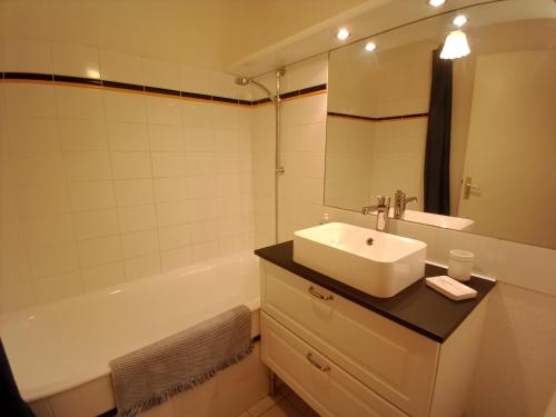 een badkamer met een wastafel en een bad bij DUPLEX les pieds dans l' eau in Jullouville-les-Pins
