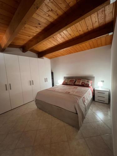 a bedroom with a bed and a wooden ceiling at Casa Nico in Montemarciano