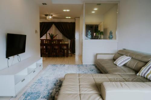 sala de estar con sofá y TV de pantalla plana en Petronella Apartment C1 Marina Court, en Kota Kinabalu