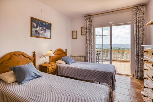 a bedroom with two beds and a balcony at Villa Casa Dolores Style Catalan in Begur