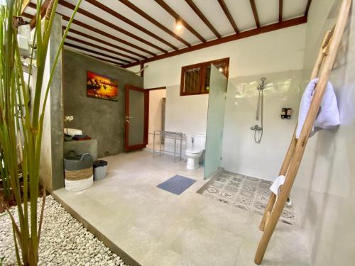 a bathroom with a shower and a toilet at Timaya Villa in Legian