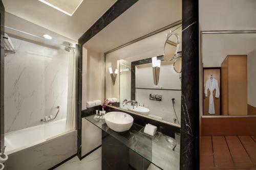 a bathroom with a sink and a large mirror at Savoy Suites Hotel Apartment - Newly Renovated in Dubai
