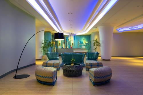 a lobby with chairs and a table in a building at Solia Legian Bali in Legian
