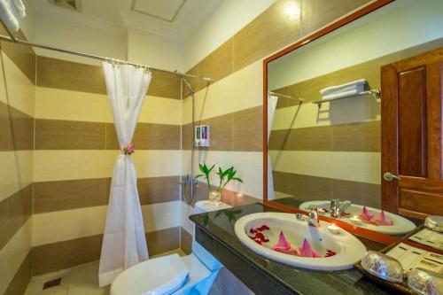 a bathroom with a sink and a toilet and a mirror at Angkor Leap Hotel in Siem Reap