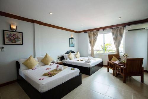 a hotel room with two beds and a table at Angkor Leap Hotel in Siem Reap