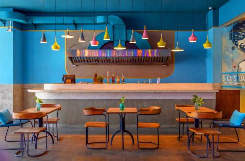 a restaurant with tables and chairs and a bar at Solia Legian Bali in Legian